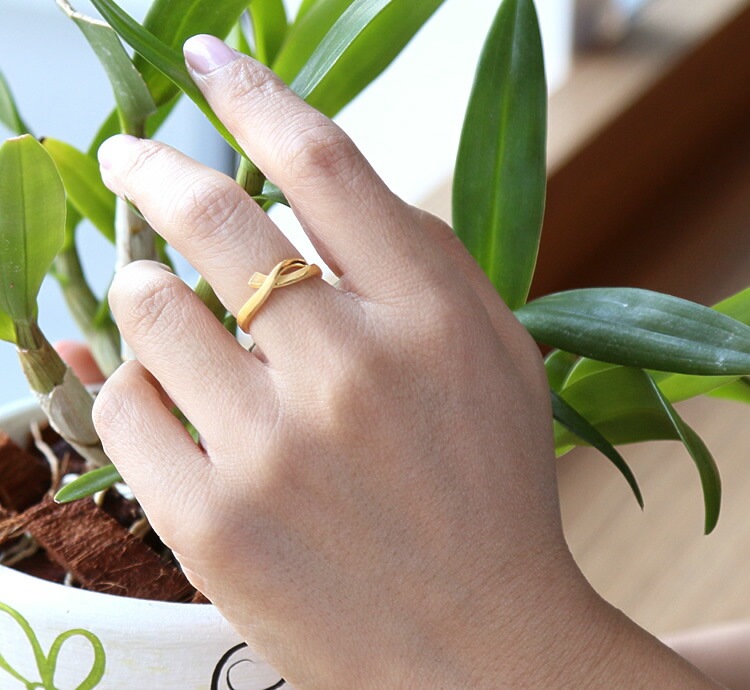 指先にしっかりと結ばれたリボン 純金リング