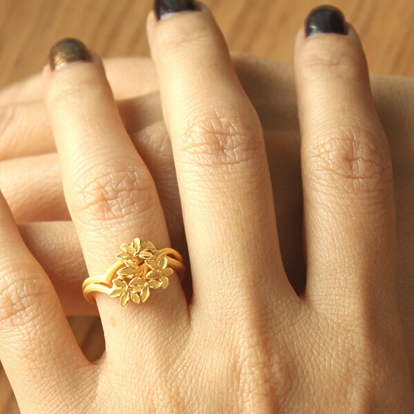 都会の光を浴び指先に凛と花咲く 純金リング