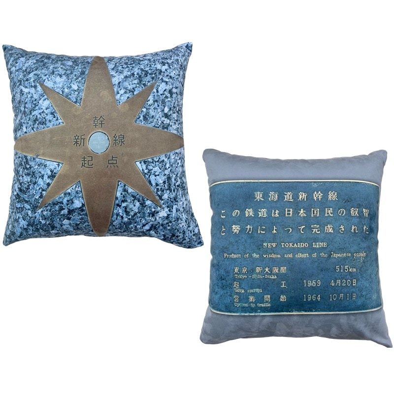 東海道新幹線東京駅のホーム上にある「0キロポスト」を示すレリーフをモチーフとしたオリジナルアイテム。
キロポストとは、その路線の起点から何キロの地点であるかを示す標識をいい、
0キロポストとは、その路線の起点を示すものです。
鹿児島中央駅まで続く線路の起点、そして、世界初の高速鉄道の出発点となった場所です。設置以来、多くのお客様、新幹線車両たちを見守ってきました。

裏面には、東京駅の東海道新幹線18番線・19番線ホームに上がる階段のところに設置されている「東海道新幹線建設記念碑」をデザイン。
東海道新幹線建設記念碑は、東海道新幹線開業の３年後となる1967年に設置されました。当時の国鉄が東海道新幹線を造ることができたのは、沿線の方々はもちろん、国民の皆さまから多大なご支援を頂戴した結果であるとし、それを末永く記録し、顕彰するためにこの記念碑は設置されたそうです。