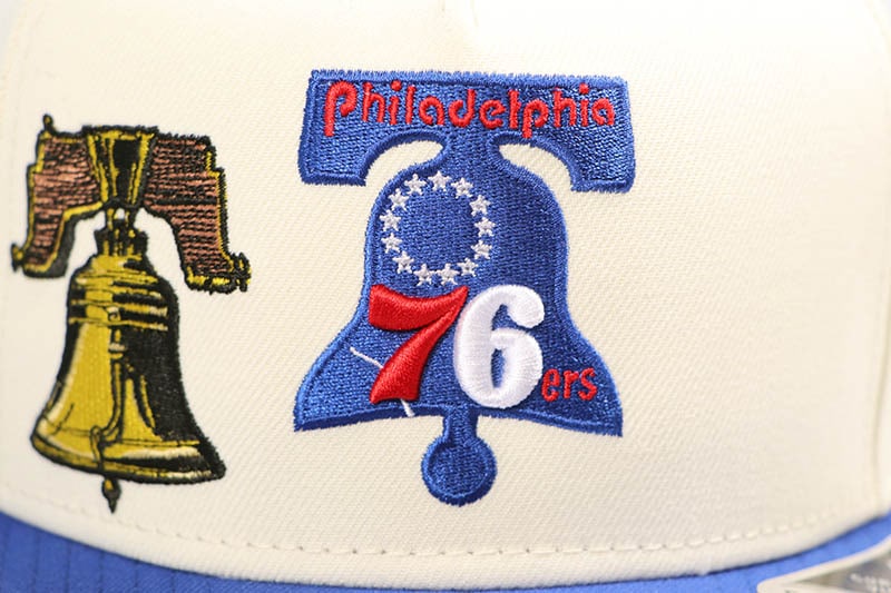 NEW ERA PHILADELPHIA 76ERS HWC AF 9FIFTY SNAPBACK CAP (LIBERTY BELL PATCH/GREY UNDER VISOR/STONE BLUE)