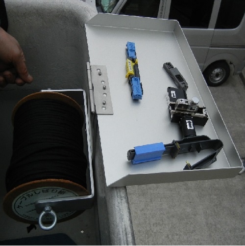 新提案!もうクレモナボビンの雨濡れの心配はありません。 雨濡れ防止カバーを裏返せば、作業台にも変身! あなたのこの先末永い工事作業を支える縁の下の力持ち! バケットボビンリール BBL-2