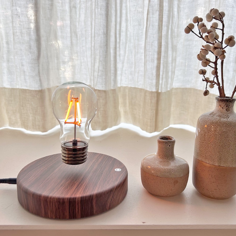 浮かぶ電球が不思議な卓上ライト。木目調デザインがインテリアに馴染む。