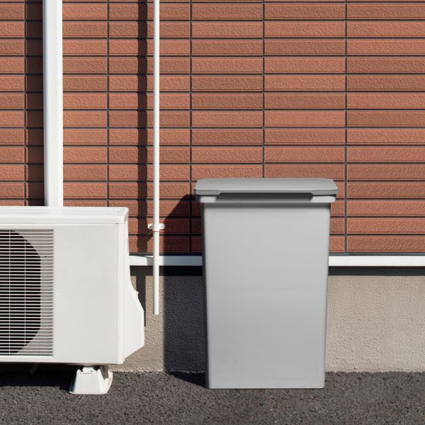 ライクイット製屋外でも使えるダストボックス52ワイドが屋外の室外機の横に設置されている様子