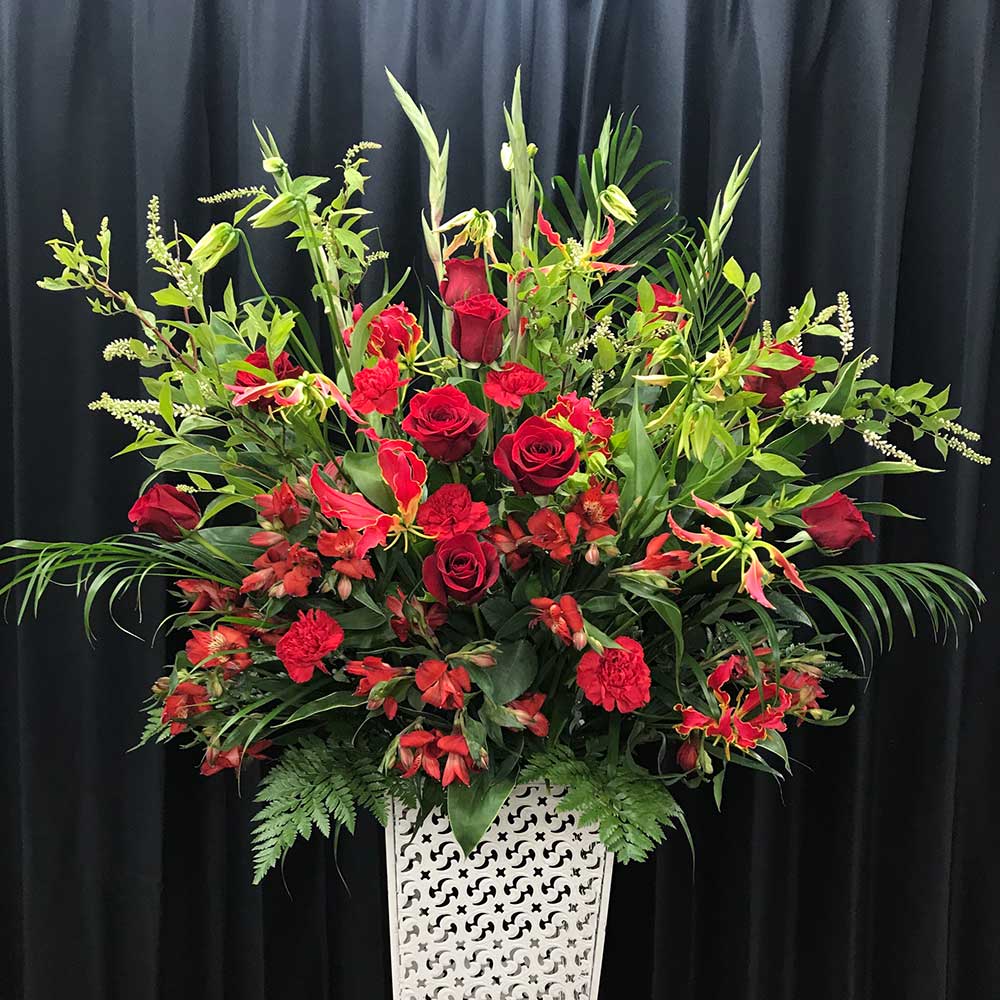 赤とグリーンの華やかなスタンド花（1段）