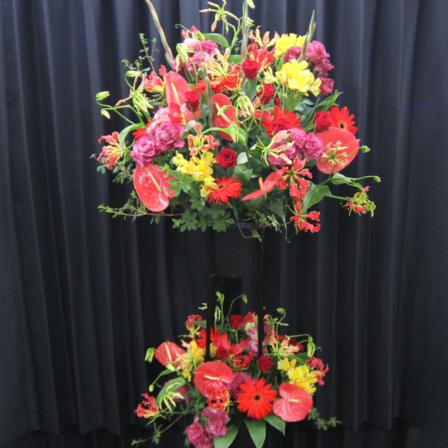 赤とイエローの華やかなスタンド花（2段）