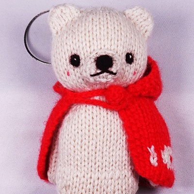 高級カシミヤの棒針の編みぐるみ。赤いマントを羽織ったブラブラ