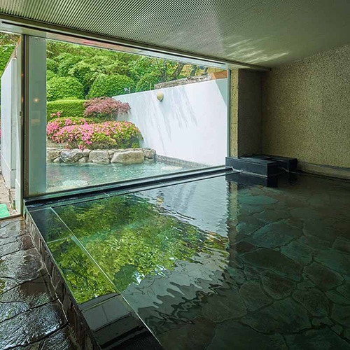 斜光や水面の揺らめきによって、繊細に色を変える天然石の大浴場