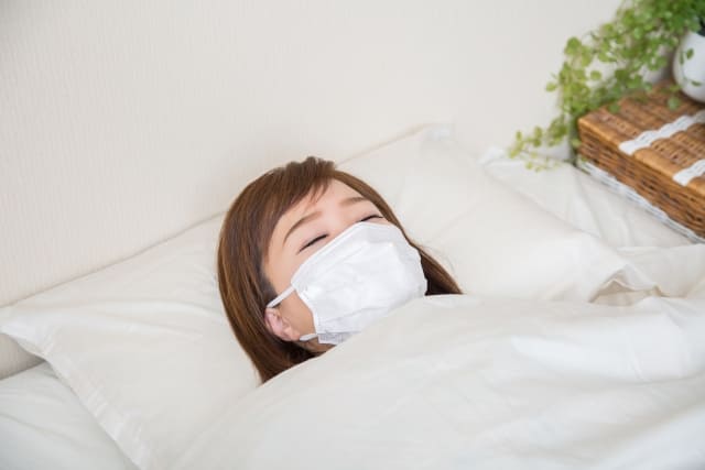 マスクを着けて寝ている女性