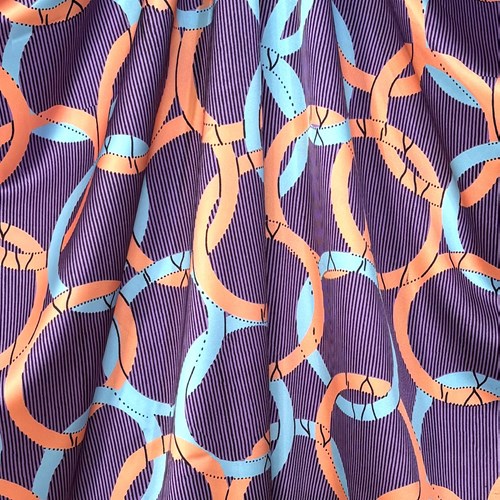 【140cm幅ｘ50cm単位】ポリエステルシルキーサテン アフリカンプリント柄 布 生地  AP-1084　オリンピア パステルオレンジ ブルー 地色パープル　ハンドメイド 手芸材料 ワンピース スカート 裏地 ダンス 舞台 衣装 に 