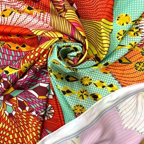 【140cm幅ｘ50cm単位】ポリエステルシルキーサテン アフリカンプリント柄 布 生地  AP-1088　大輪の南国花にジュエリー ピンクオレンジ系マルチカラー 薄グリーン　ハンドメイド 手芸材料 ワンピース スカート 裏地 ダンス 舞台 衣装 に